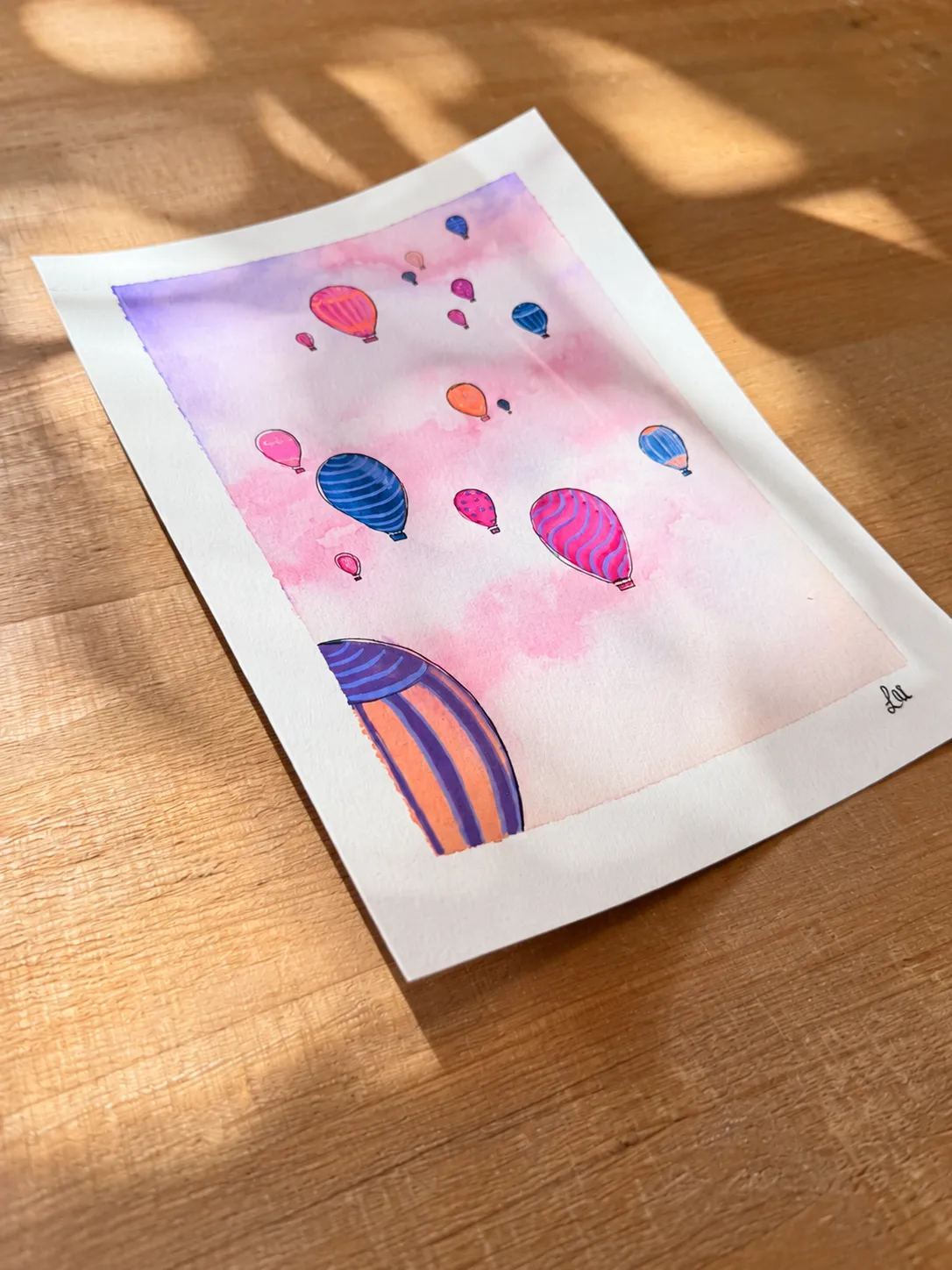Close angled view of hot air balloon watercolor in dappled sunlight
